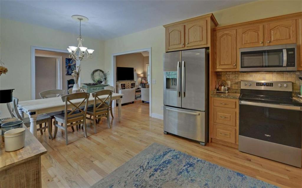 234 Dh Green Road Demorest, GA 30535 - Photo 13 of 57 a kitchen with stainless steel appliances granite countertop a refrigerator a stove a sink a dining table and chairs with wooden floor