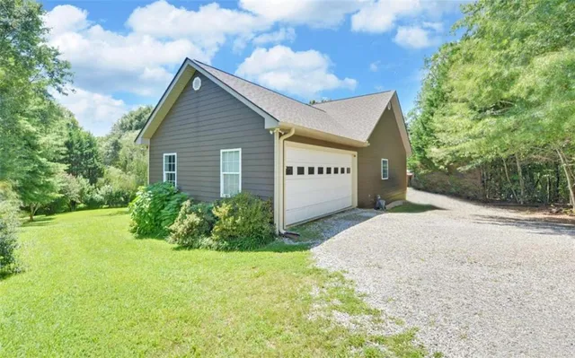 an aerial view of residential house with outdoor space and trees all around