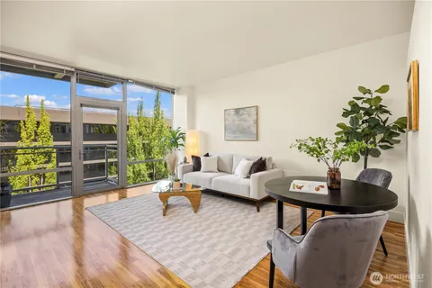 a living room with furniture potted plant and a large window