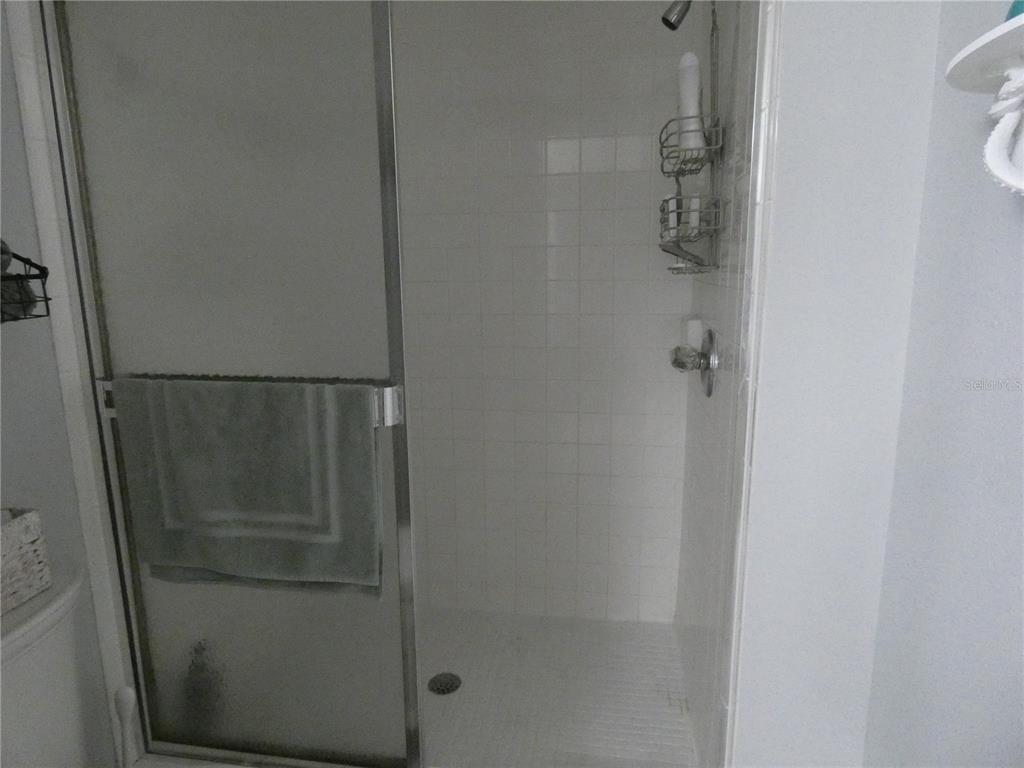 9320 Clubside Circle, Unit 2208 Sarasota, FL 34238 - Photo 18 of 41 a bathroom with a glass shower door
