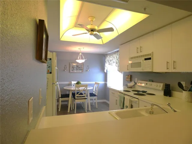 a kitchen with stainless steel appliances granite countertop a sink a stove and a refrigerator