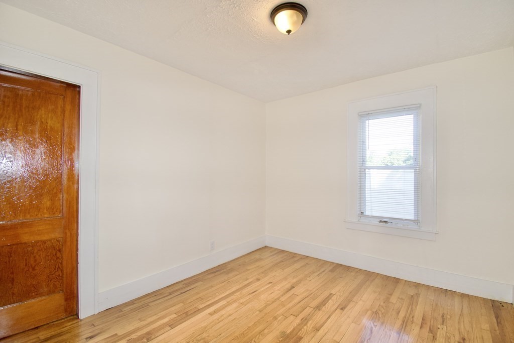 19 Ambrose Street Springfield, MA 01109 - Photo 12 of 32 an empty room with wooden floor and windows