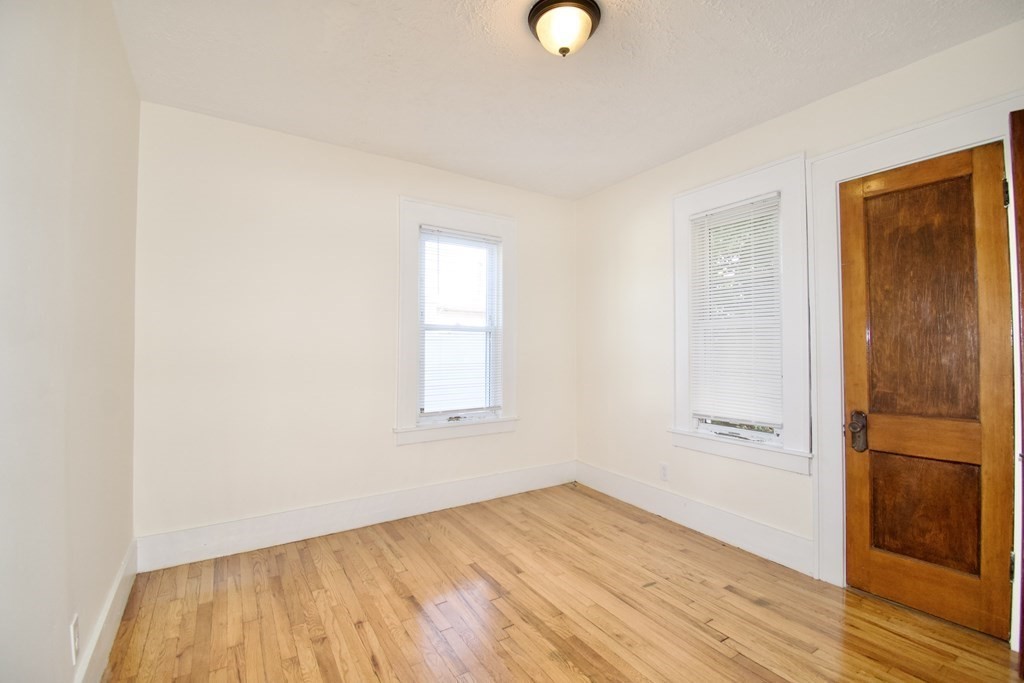 19 Ambrose Street Springfield, MA 01109 - Photo 13 of 32 an empty room with wooden floor and windows