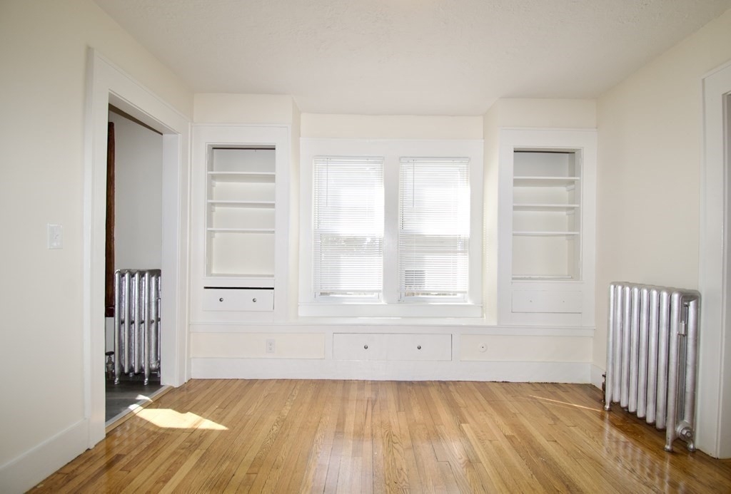 19 Ambrose Street Springfield, MA 01109 - Photo 5 of 32 an empty room with wooden floor and windows