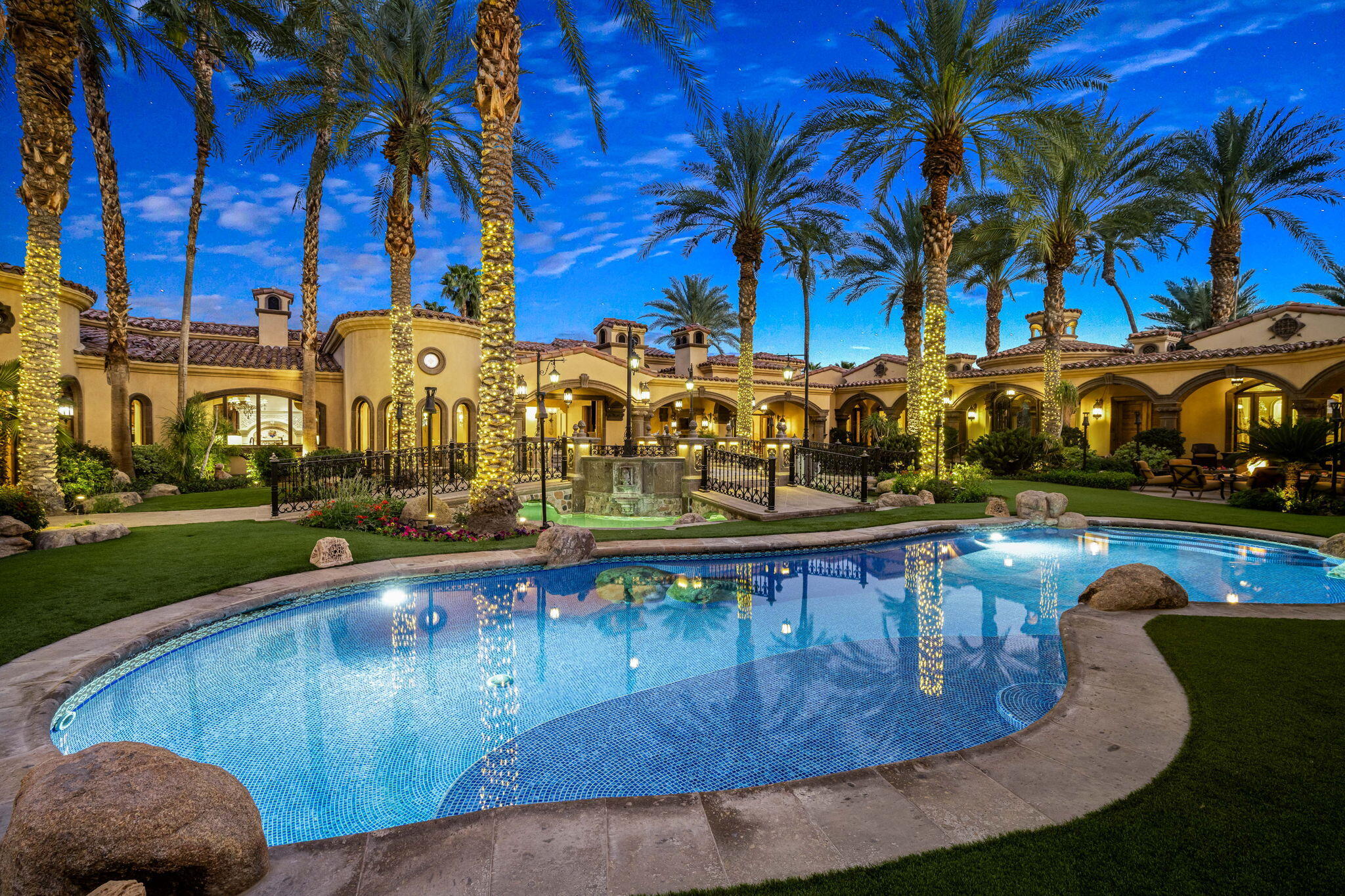 14 Strauss Terrace Rancho Mirage, CA 92270 - Photo 95 of 115 a view of a swimming pool with a lawn chairs under palm trees