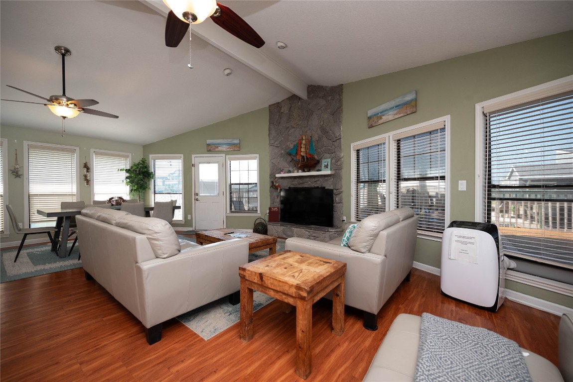 4729 Jolly Roger Road Jamaica Beach, TX 77554 - Photo 13 of 45 a living room with furniture a ceiling fan a fireplace and a large window