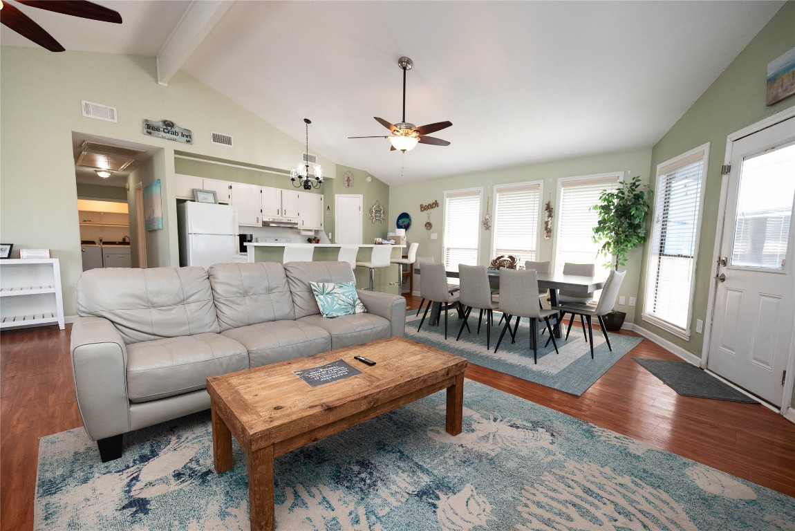 4729 Jolly Roger Road Jamaica Beach, TX 77554 - Photo 20 of 45 a living room with furniture a wooden floor and a chandelier