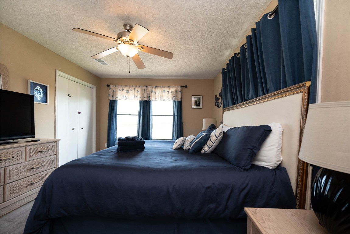 4729 Jolly Roger Road Jamaica Beach, TX 77554 - Photo 24 of 45 a bedroom with a bed window and a flat screen television