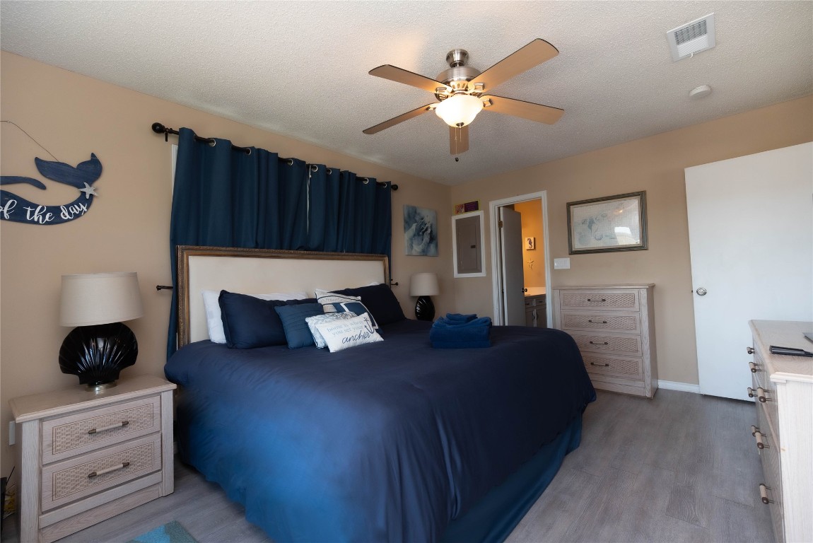 4729 Jolly Roger Road Jamaica Beach, TX 77554 - Photo 25 of 45 a bedroom with a bed and a chandelier