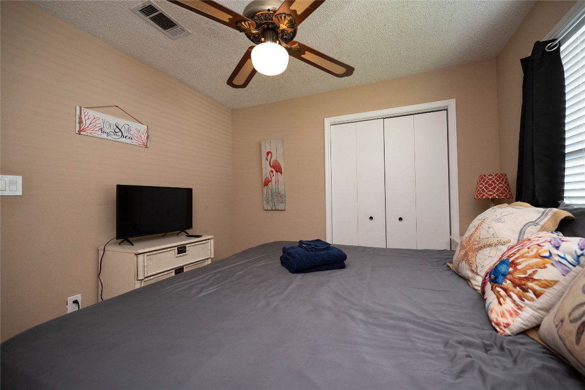 4729 Jolly Roger Road Jamaica Beach, TX 77554 - Photo 29 of 45 a bedroom with a bed and a flat tv screen on dresser