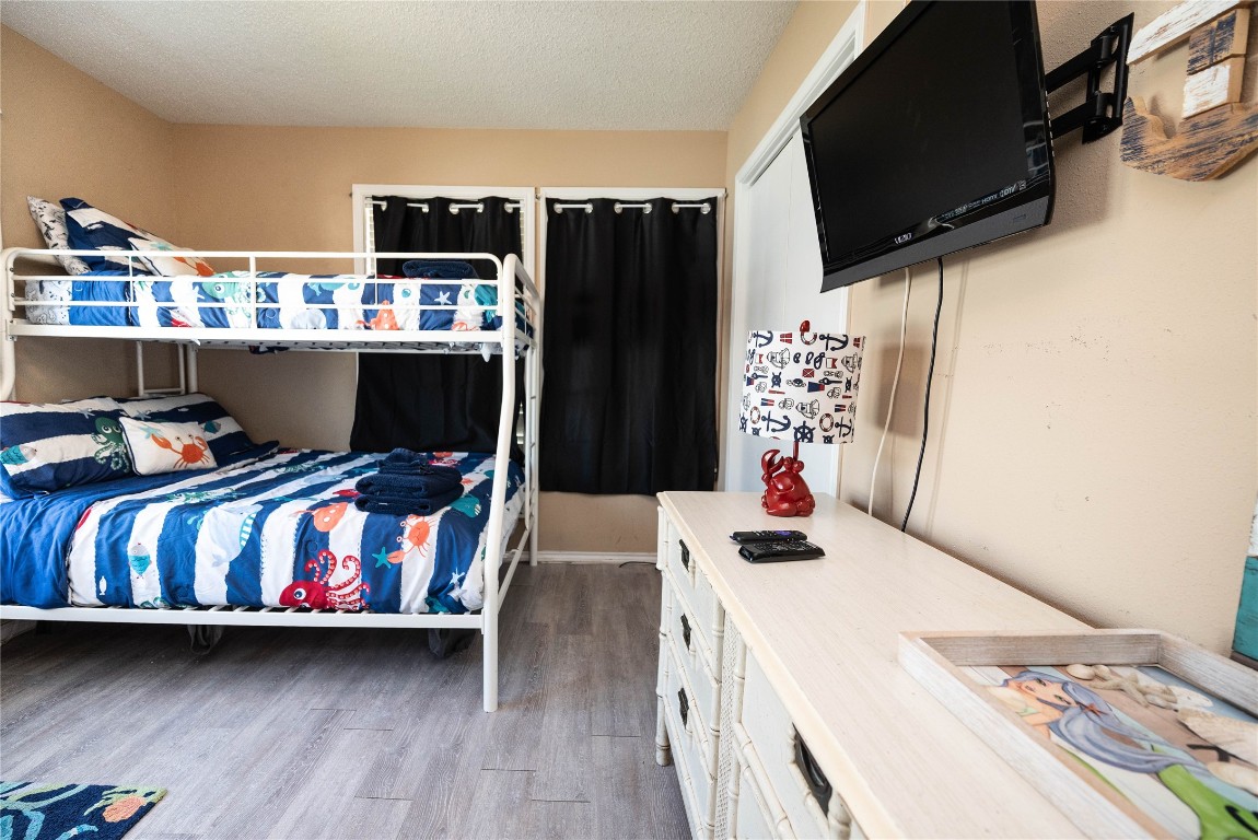 4729 Jolly Roger Road Jamaica Beach, TX 77554 - Photo 34 of 45 a bedroom with a bed a dresser and book shelf