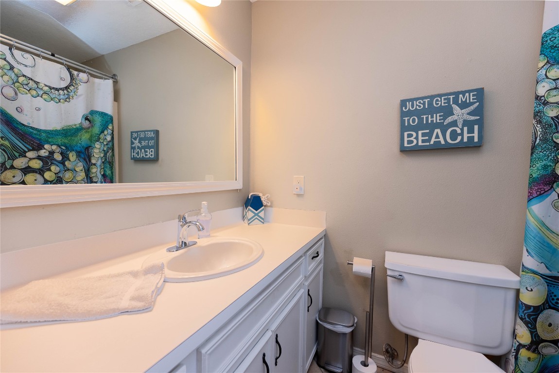4729 Jolly Roger Road Jamaica Beach, TX 77554 - Photo 35 of 45 a bathroom with a sink mirror vanity and toilet