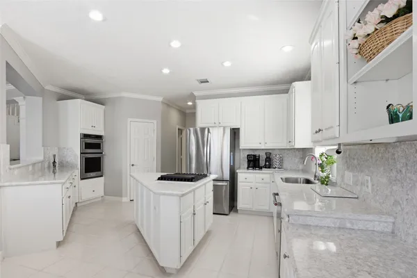 a kitchen with stainless steel appliances a refrigerator sink and white cabinets