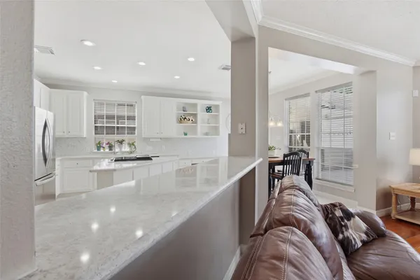 a large kitchen with kitchen island a large counter top space a sink stainless steel appliances and cabinets