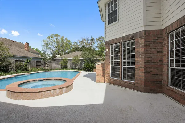 a view of a house with a swimming pool and sitting area