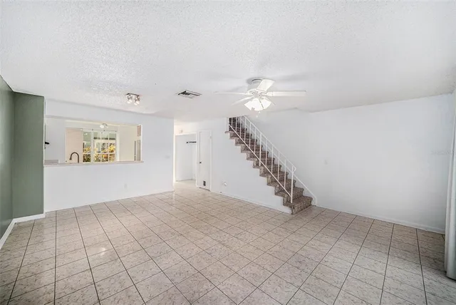 a view of an empty room with a chandelier fan