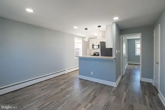 a view of a kitchen with wooden floor and a sink