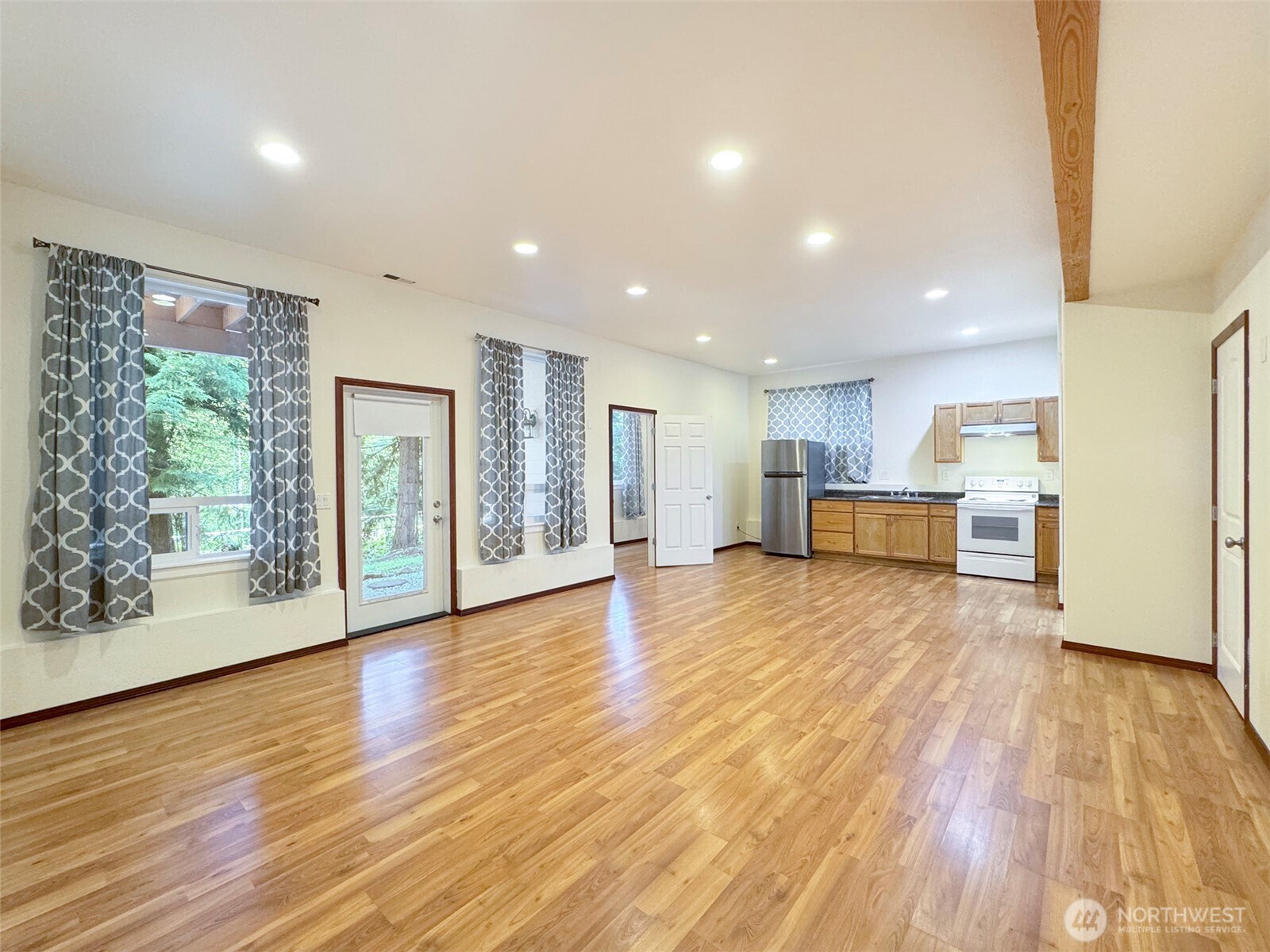 60 Alderwood Drive Sequim, WA 98382 - Photo 28 of 40 a view of empty room with wooden floor and kitchen view