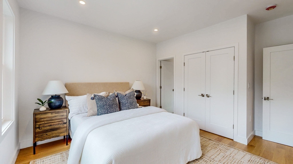 140 Columbia Street, Unit 1 Brookline, MA 02446 - Photo 19 of 41 a bedroom with a bed and wooden floor