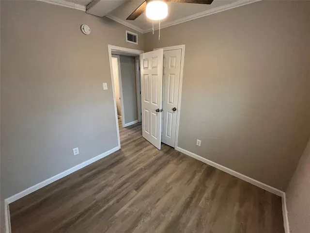 a view of an empty room and chandelier fan