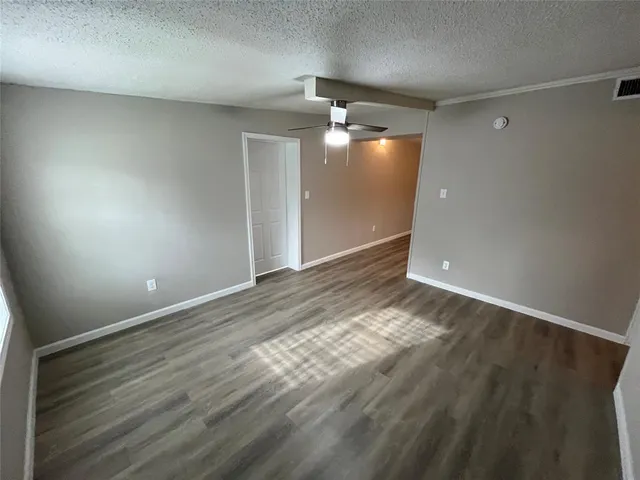 an empty room with wooden floor mirror and windows