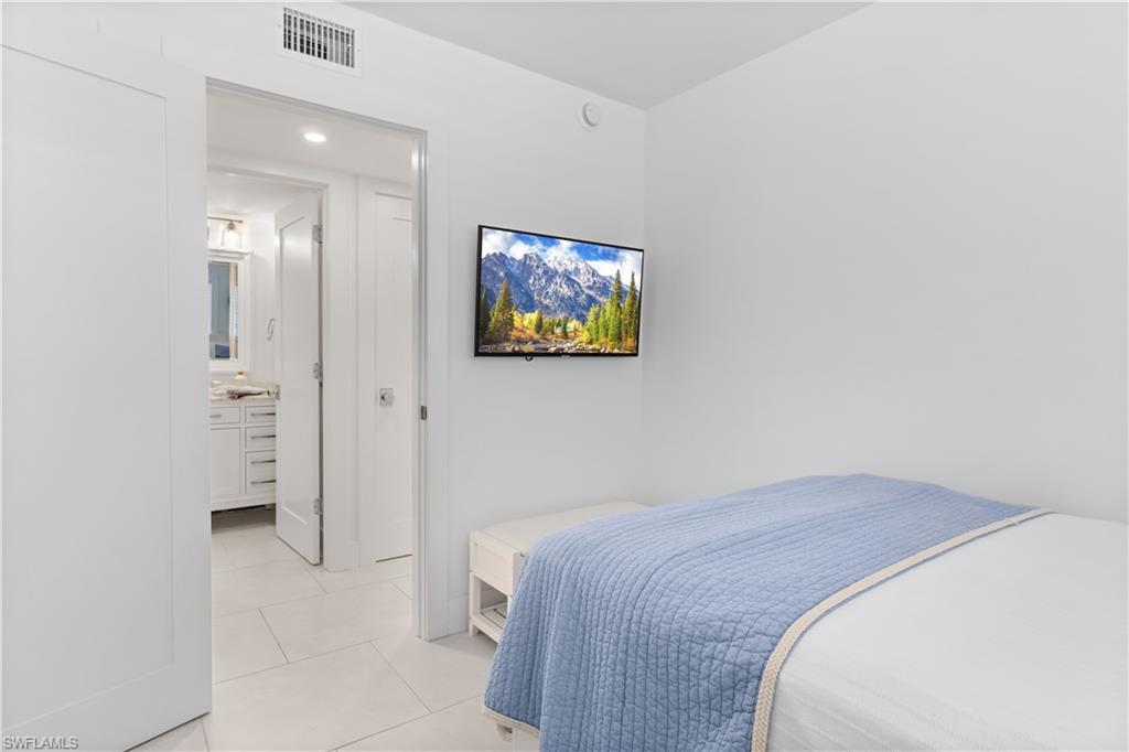 900 8th Avenue South, Unit 105 Naples, FL 34102 - Photo 14 of 20 a bedroom with a bed and a painting on the wall