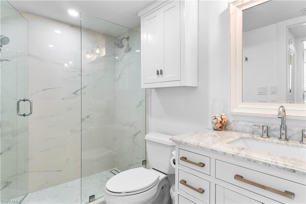 900 8th Avenue South, Unit 105 Naples, FL 34102 - Photo 15 of 20 a bathroom with a granite countertop sink a toilet and shower