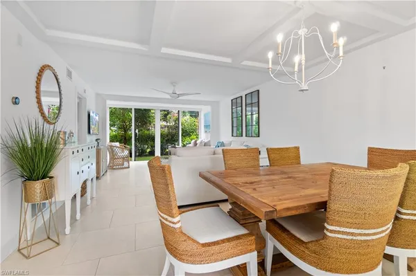 a view of a dining room with furniture a livingroom and chandelier
