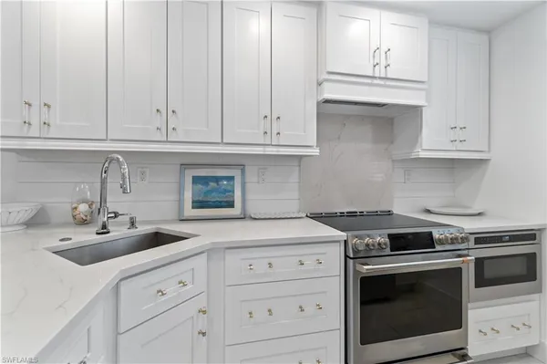a kitchen with white cabinets and white appliances