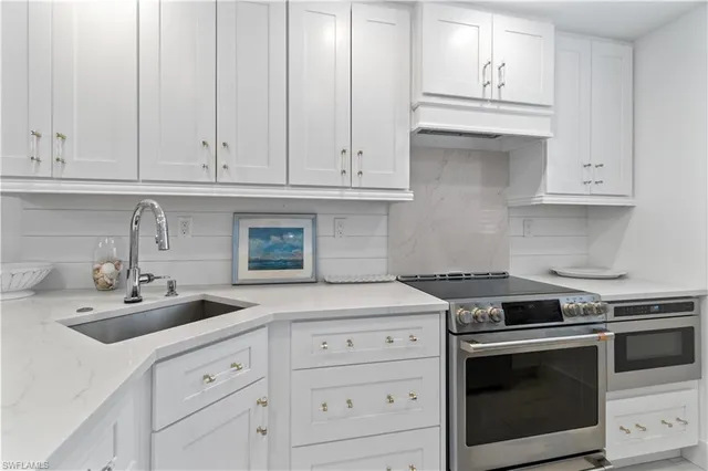 a kitchen with white cabinets and white appliances