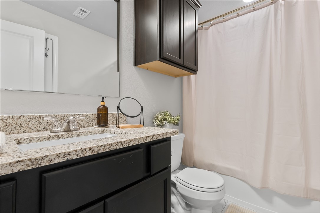 1925 Viva Road Bryan, TX 77807 - Photo 17 of 26 a bathroom with a granite countertop sink toilet and shower