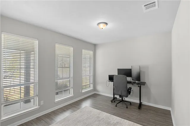 a view of a workspace with furniture and a window