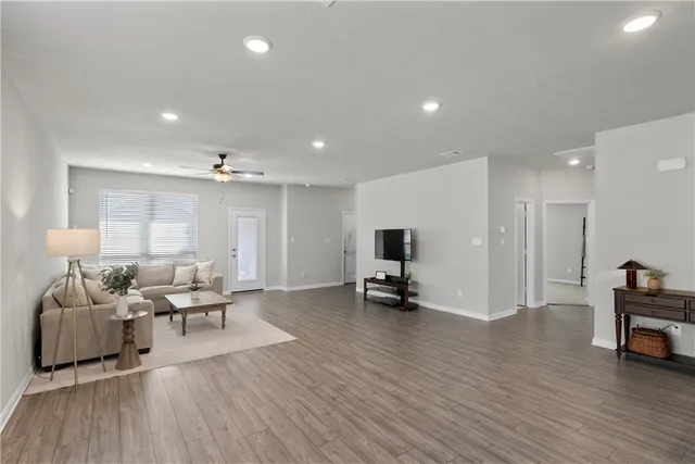 a large kitchen with kitchen island a sink dishwasher a dining table and chairs with wooden floor