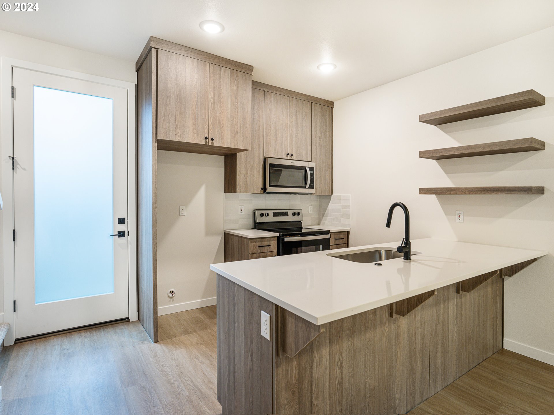 8524 North Endicott Avenue, Unit 2 Portland, OR 97217 - Photo 5 of 12 a kitchen with a sink a microwave a refrigerator and cabinets