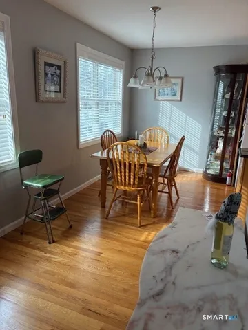 a dining room with furniture window and wooden floor