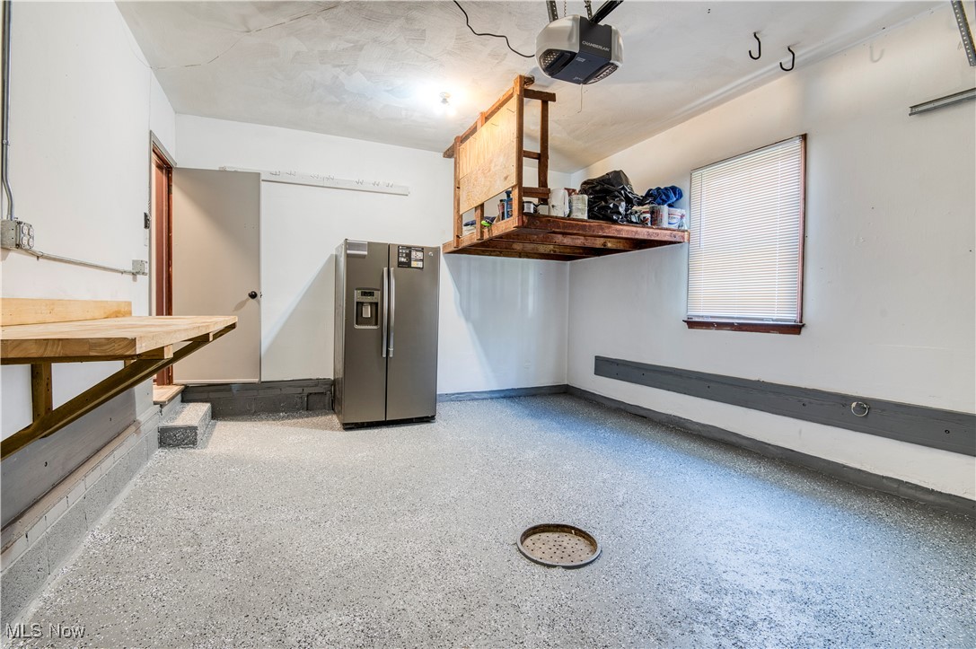 4520 Birchwold Road Cleveland, OH 44121 - Photo 30 of 40 Garage featuring a garage door opener and stainless steel fridge