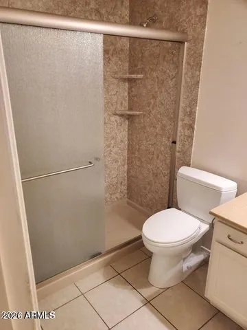 a white toilet sitting next to a shower