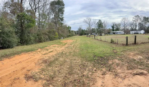 a view of a field with trees in the background