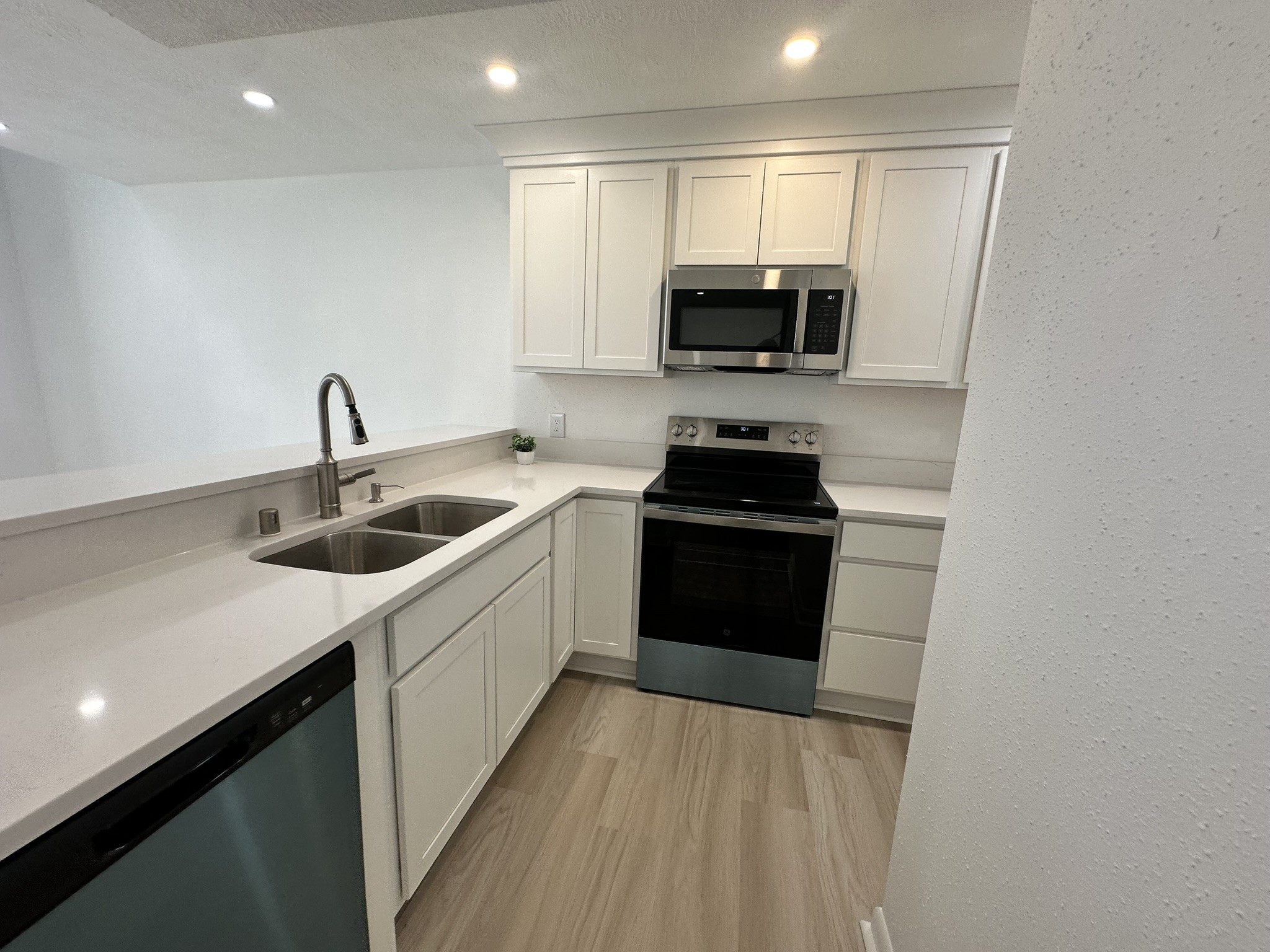 2800 Jeanetta Street, Unit 203 Houston, TX 77063 - Photo 11 of 34 a kitchen with stainless steel appliances a sink a stove top oven a refrigerator with white cabinets and wooden floor