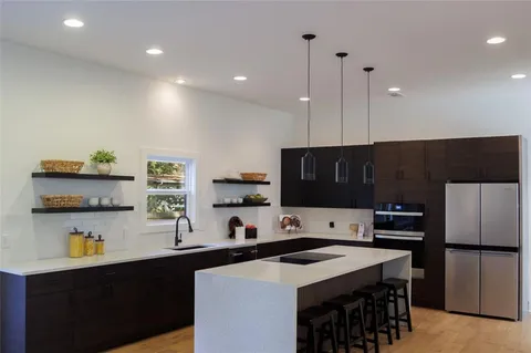 a kitchen with stainless steel appliances a stove refrigerator sink and cabinets