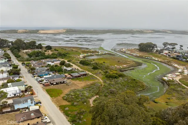 an aerial view of ocean and residential houses with outdoor space