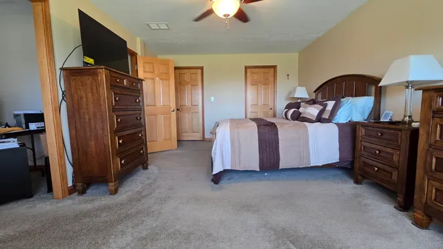 a spacious bedroom with a bed and a chandelier