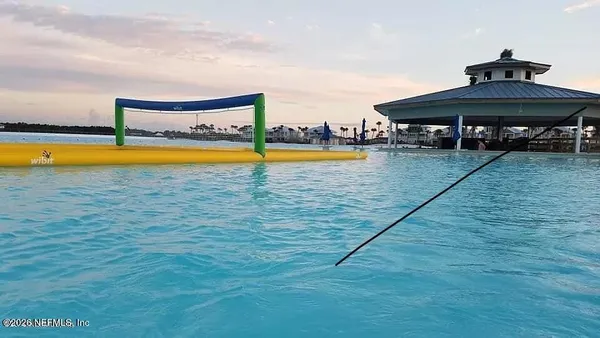 a view of a swimming pool with lawn chairs under an umbrella