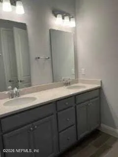 a bathroom with a double vanity sink and a mirror