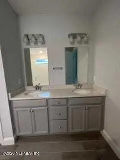 a bathroom with a double vanity sink and a mirror