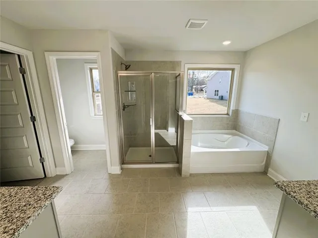 a bathroom with a tub shower and toilet
