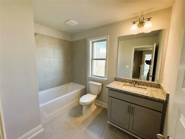 a bathroom with a sink toilet a mirror and bathtub