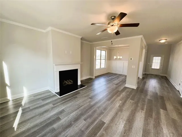a view of an empty room with wooden floor and a fireplace