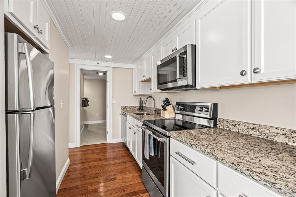 175 Bridge Road Salisbury, MA 01952 - Photo 14 of 42 a kitchen with stainless steel appliances granite countertop a refrigerator a stove and a sink with wooden floor