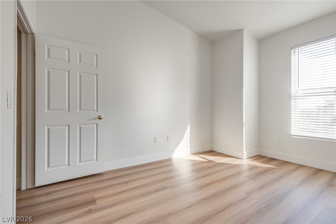10550 West Alexander Road, Unit 2174 Las Vegas, NV 89129 - Photo 14 of 28 Crisp walls and smooth wood-style flooring create a clean slate in this versatile room.